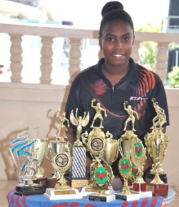 Marian Academy’s young tennis star Priscilla Greaves poses with some of her trophies for Kaieteur Sport recently.  