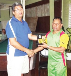 Shiek Mohamed (right) receives the man- of- the- match award from president of the Florida Cricket Academy Wayne Ramnarine.