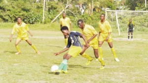 Boxed in! East Bank player Nicholai Matthews (with ball) is closely monitored by four Berbice players on Saturday afternoon at the Grove Playfield.     