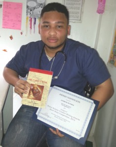 Andrew Hutson displays his book and a certificate for participating in the 2014 Walter Rodney Creative Writing Short Story Competition.