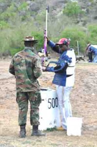 Lennox Braithwaite weighing his trigger under the supervision of the Range Officer to ensure it is within the limits after shooting the days only possible at 500 yards range.