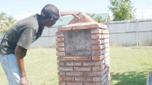 A Victoria lad tries to read the inscription on this monument  dedicated to the freed African slaves who bought the village. 
