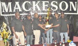 Mackeson Brand Manager Jamal Douglas (third, left) hands over the Championship trophy and cash prize to West Front Road captain, Hubert Pedro, yesterday.