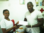 Supervisor of Morgan’s Learning Centre, Ms. Melissa King hands over the cheque to Dexter Garnett. 