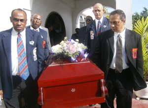 Peter Abdool (right) is joined by Andrew Thorne (left), Trevor Arno (2nd left), Francis Abraham (2nd right) and Carlton Hopkinson as they carry their colleague to the hearse. 