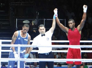 Dennis Thomas (right) of Guyana gets his hand raised by the referee after his 3-0 verdict over Jonathon Keama of Papua New Guinea. 