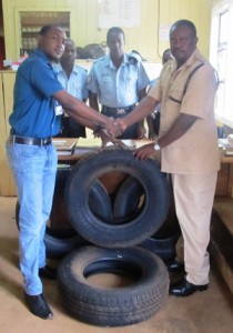 Macorp Port Kaituma Branch Administrator, Kareb Price, hands over a donation of tyres to Asst Supt Winter.