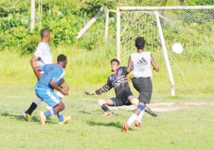 Sherwin Fordyce of Mocha Champs (left) scores the goal that gave his team their first point.