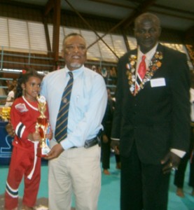 Prime Minister, Sam Hinds presents the youngest practitioner, Trinidadian Ariana Ragbarsingh with her prize in the presence of Professor Christopher Francis 
