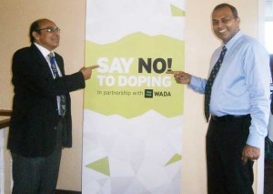 Minister of Sports,  Dr. Frank Anthony (right) and President of the GOA points to the message, displayed at the workshop Saturday morning.  