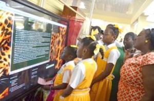 Students trying out the 81-inch touch screen computers at the Guyana National Museum