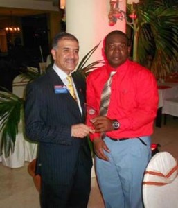(In photo, Toastmaster Travis Ferreira displaying his award with Toastmasters International President, Mohammed Murad, DTM)