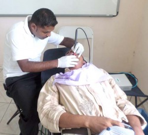 Dentist, Abdul Raheem deep-cleaning the teeth of a patient.