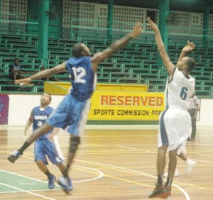 Jason Squires (right) releases a jumper just inside the three-point line with the defence flying in his face Sunday night at the Cliff Anderson Sports Hall. 