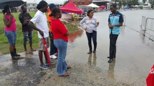 Minister of Education, Priya Manickchand (second, right) and Principal Assistant Secretary with the Ministry of Education, Glendon Fogenay (right) in discussion with GTU Officials (left) at the inundated GDF Base Camp Ayanganna Ground, yesterday morning.