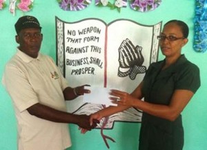 Ms Natasha Dey, Secretary of the Arokium Funeral Home hands over the sponsorship cheque to organiser and coach Randolph Roberts.