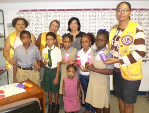 (From left) President of the Lions Club of D’Urban Park, Zaleena Lawrie, a club member, Optometrist, Michelle Ming and Lions Club of D’Urban Park member, Odetta Fogenay, along with some of the students who received spectacles.