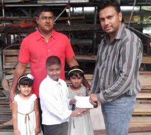 Young Javed Yunas of the Yunas Civil and Building Construction Services along with Zaila, Saria and owner Fazil  Younas  presents their sponsorship cheque to an organising committee member.  