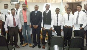 Natural Resources Minister, Robert Persaud (fourth from left), with officials and the eight new land surveyors.