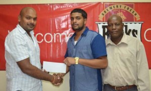 A Banks DIH Rep presents the cheque to coordinator Nasrudeen (Jumbo Jet) Mohamed junior (right) and assistant organizer and race commentator Campton Sancho at the company’s headquarters at Thirst Park.