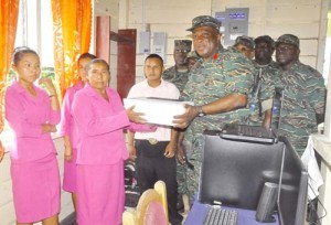 Brigadier Phillips hands over a computer system to teachers of Kaikan Primary School.