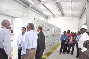 Prime Minister Sam Hinds with GPL officials and others inside the North Ruimveldt control centre sub-station yesterday.
