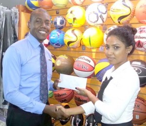 Giftland OfficeMax Marketing Representative, Delroy Dash (left) hands over their contribution to ‘Respect the Game’s’ Director, Surika Danraj yesterday at its Water Street Department Store for the upcoming Charity Basketball showdown.