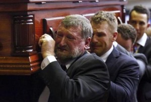 Gregory Hughes (front), the father of Australian cricketer Phillip Hughes, cries as he carries his son’s casket past mourners after his funeral service in the town of Macksville, located north of Sydney, December 3, 2014. REUTERS/Cameron Spencer/Pool