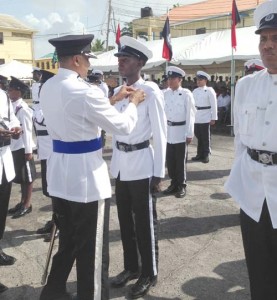 Commissioner of Police (Ag) Seelall Persaud pins the force’s 175th Anniversary Medal on one of the ranks.   