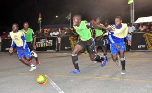 Two players fight for possession of the ball during one of the games in Round of 16 action on Wednesday night at the National Cultural Centre Tarmac.