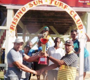  Trainer R. Bharrat of the Romel Jagroop Stable receives the winning Two Year old Trophy for Midnight Blue victory from a representative of the organisers. 
