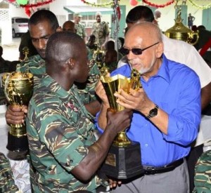 President Donald Ramotar being offered a sip from the “Trophy” by a rank of the Guyana Defence Force