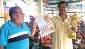 Mr. Ramjattan and Dr. Ramayya with Mr. Lall’s trophy as they hold up a copy of yesterday’s Kaieteur News