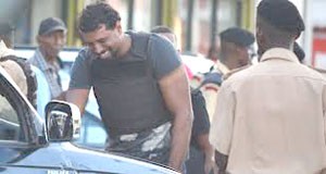 A Guyanese policeman weeps at the scene of a shootout that left two of his colleagues dead.