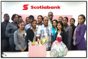 Staff of Scotiabank Berbice branch hand  over food hamper to Alpha Children's Home