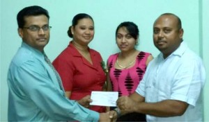 Shipping Manager of Muneshwar’s Shipping Mr. Brian Pertab (left) hands over the cheque to LGC President Mr. David Mohamad in the presence of other staff members. 