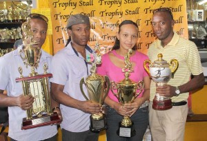 Alexis Barrington, representing Trophy Stall, presented the Championship trophy to President of the UDFA Collis Gifth (right), while two other representatives from the UDFA share the moment as they display the third place and runner-up trophies. 