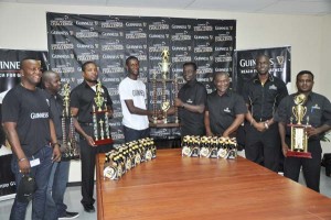 Guinness Sales Representative of West Demerara Ezekiel Baird (right) hands over the winning trophy to Tournament Coordinator Travis Bess in the presence of Guinness Brand Manager Lee Baptsite (2nd right), Communications Manager Troy Peters (3rd right) and other officials yesterday.