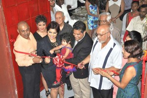 President Ramotar and his wife, First Lady Deolatchmee, join the owners of the confectionery company in the ceremonial ribbon-cutting exercise.