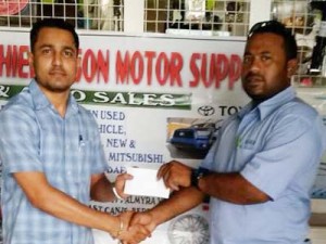 Ray Jahoor (left) presents the sponsorship to Ishwar Singh of the YWCC.