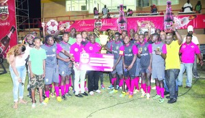 Banks DIH executives, Brian Choo Hen and Troy Peters hand over the winning cheque and trophy to Alpha captain, Dwight Peters during the presentation ceremony last Thursday evening 