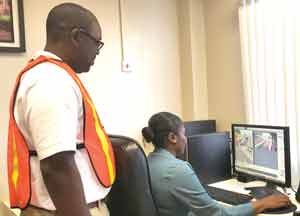 General Manager of the DHB, Rawlston Adams looks on as a staffer monitors the bridge’s security cameras shortly after the tragedy 