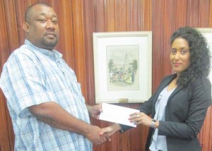 Ms. Patricia Bacchus of Caribbean Containers Inc hands over cheque to Secretary/CEO of the RHTYSC  Hilbert Foster 