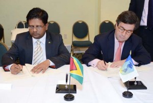 Minister of Finance, Dr. Ashni Singh (left) signing the agreements with President of the IDB, Luis Alberto Moreno. 