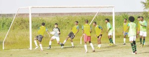 Queenstown goalkeeper and defenders seen under pressure from the defending champions Lodge during their encounter yesterday.