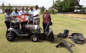 MSC head Neil Barry (second from right) receives the grass-cutter from Minister of Sport Dr. Frank Anthony (third from left) in the presence of other members of the club.  