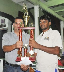 GCC’s Graeme Alli (left) presents the wining trophy to captain of the victorious Regal team Mohamed Ayube. 