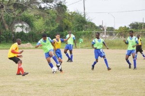 A St. Stanislaus College defender heads the ball away from his penalty area following a cross from the right side in their clash against South Ruimveldt yesterday.