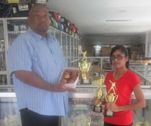 This Tiger Sports representative and Hilbert Foster display the trophies and balls. 