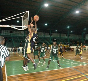 Guardians forward, Trenton Woolford (#11) attempts a base-line fade-away jumper in heavy Jets traffic Sunday night when the National Basketball Championships opened at the Cliff Anderson Sports Hall.
